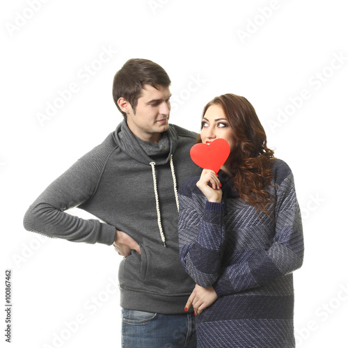 Ordinary beautiful couple having fun with a paper heart on Valentine's Day. On a white background.