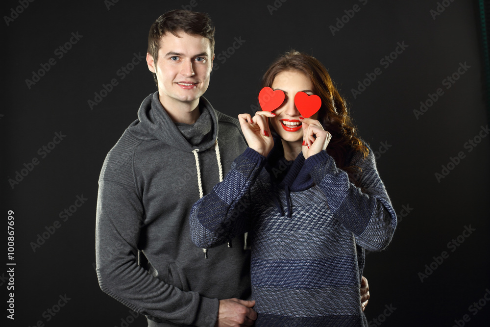 Ordinary beautiful couple having fun with a paper hearts on Valentine's Day. On a black background. Ordinary beautiful couple having fun with a paper hearts on Valentine's Day. On a black background.