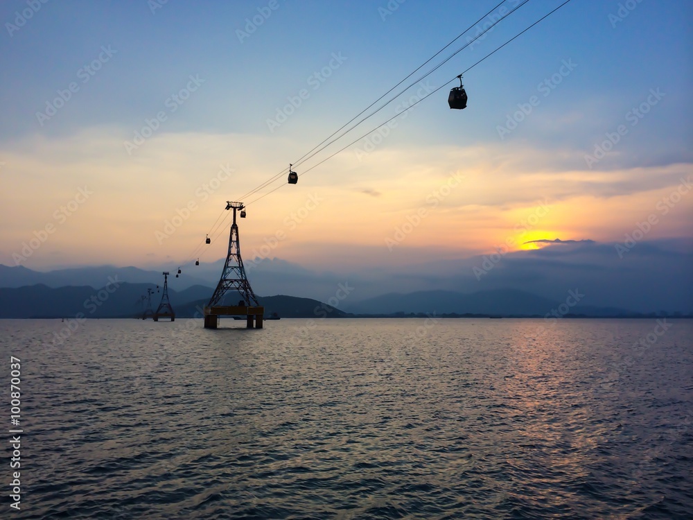 Cable car with cloudy sky on the background at sunset