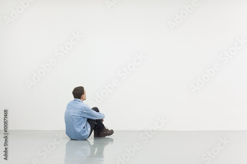 Man sitting in front of a white wall