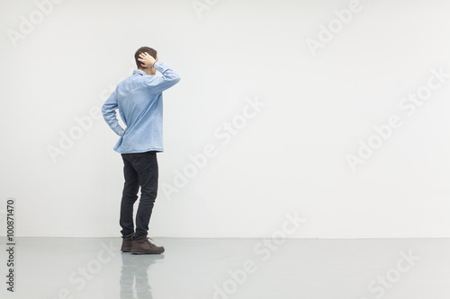 Man standing in front of a white wall, concept of thinking, making ideas