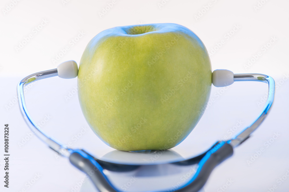 Green apple with doctors stethoscope.  - obrazy, fototapety, plakaty 