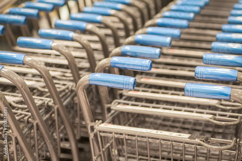 Rows of shopping carts at supermarket entrance.