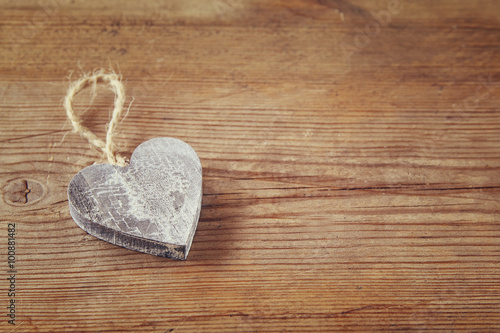 selective focus photo of wooden heart on rustic table.  valentine's day celebration concept. vintage filtered and toned