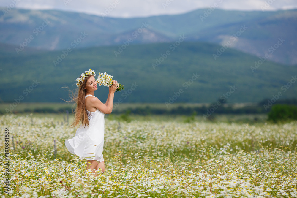 Beautiful young woman in a field of blooming daisies Beautiful young woman in a field of blooming daisies