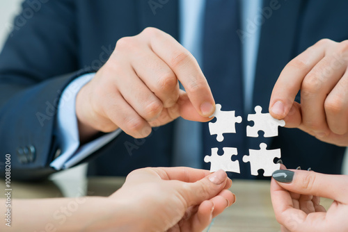 Office workers holding puzzles 