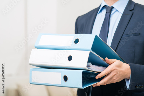 Professional office worker holding folders 