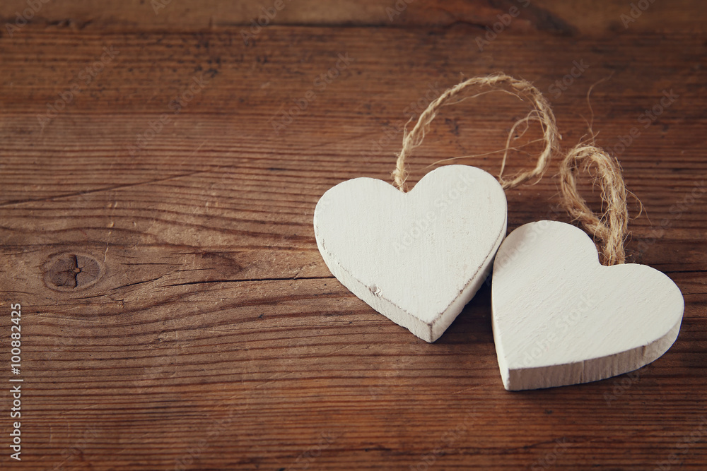 selective focus photo of couple of wooden hearts on rustic table. valentine's day celebration concept. vintage filtered selective focus photo of couple of wooden hearts on rustic table. valentine's day celebration concept. vintage filtered