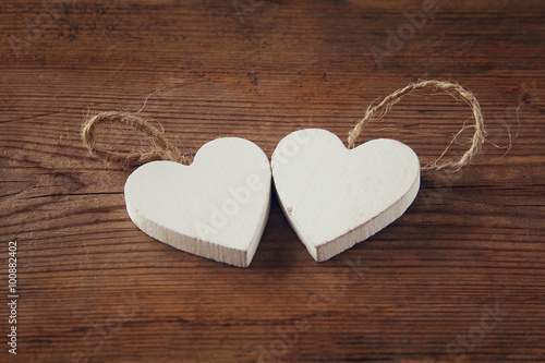 selective focus photo of couple of wooden hearts on rustic table. valentine's day celebration concept. vintage filtered