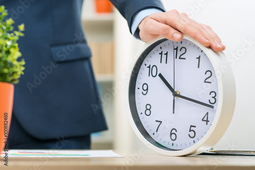 Fotografija Pleasant office worker holding clock