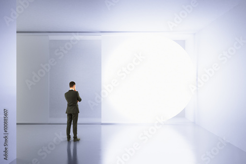 A man stands in an empty white room with copy space