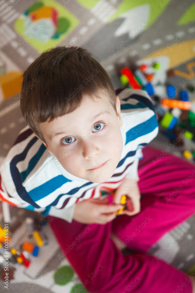 Little kid boy playing with lots of colorful plastic blocks indoor. Child having fun with building and creating Little kid boy playing with lots of colorful plastic blocks indoor. Child having fun with building and creating
