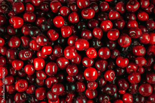 Tela background filled with juicy red  berries. Cherry, cherries