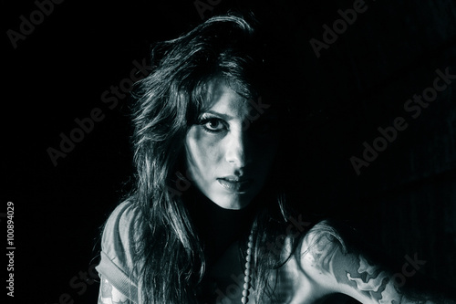 Monochrome portrait of young woman in dramatic high contrast lighting