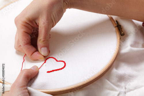 Woman sewing a Red Heart Shaped Decoration