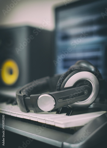 Audio earphones. Home recording studio with professional monitors and midi keyboard.