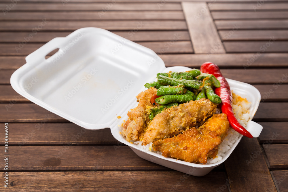 Convenient but unhealthy polystyrene lunch boxes with take away meal on wooden table Convenient but unhealthy polystyrene lunch boxes with take away meal on wooden table