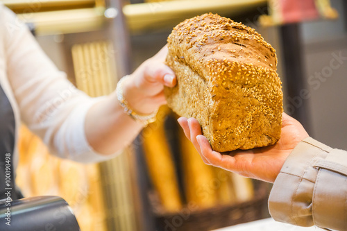 closeup of a hand giving bread to the customer