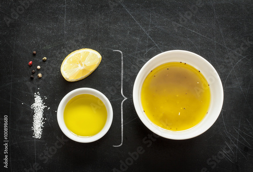 Fotografija Lemon vinaigrette dressing - recipe ingredients on black chalkboard background from above