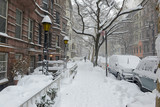Snow covered street with Brownstone apartment buildings near Central Park during snowstorm in New York City