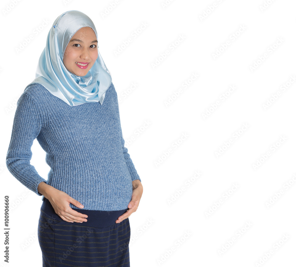 Young expecting pregnant Muslim mother with hijab over white background Young expecting pregnant Muslim mother with hijab over white background