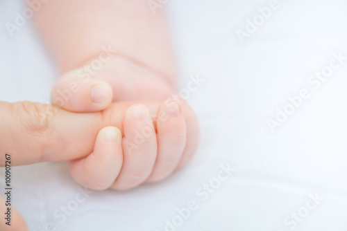 Infant holding finger of the mother 