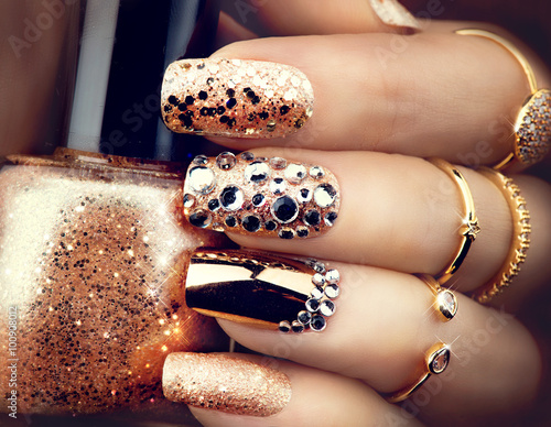 Obraz na płótnie Golden holiday style bright manicure with gems and sparkles