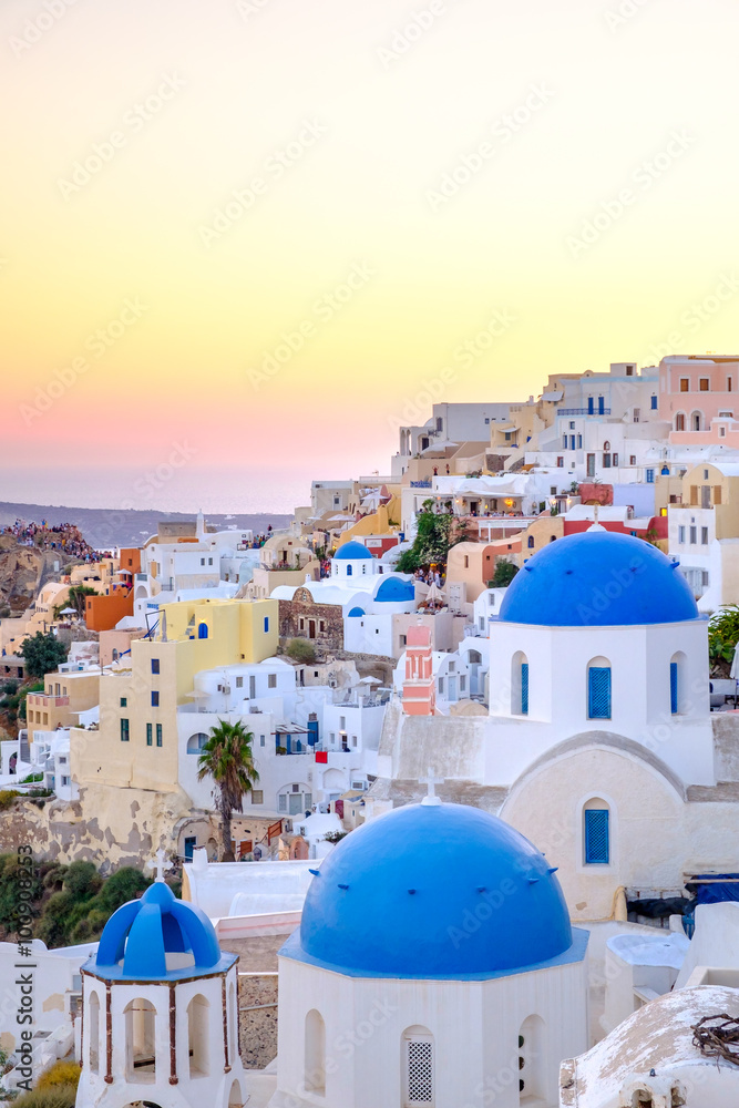 Scenic view of colorful houses and blue domes at sunset