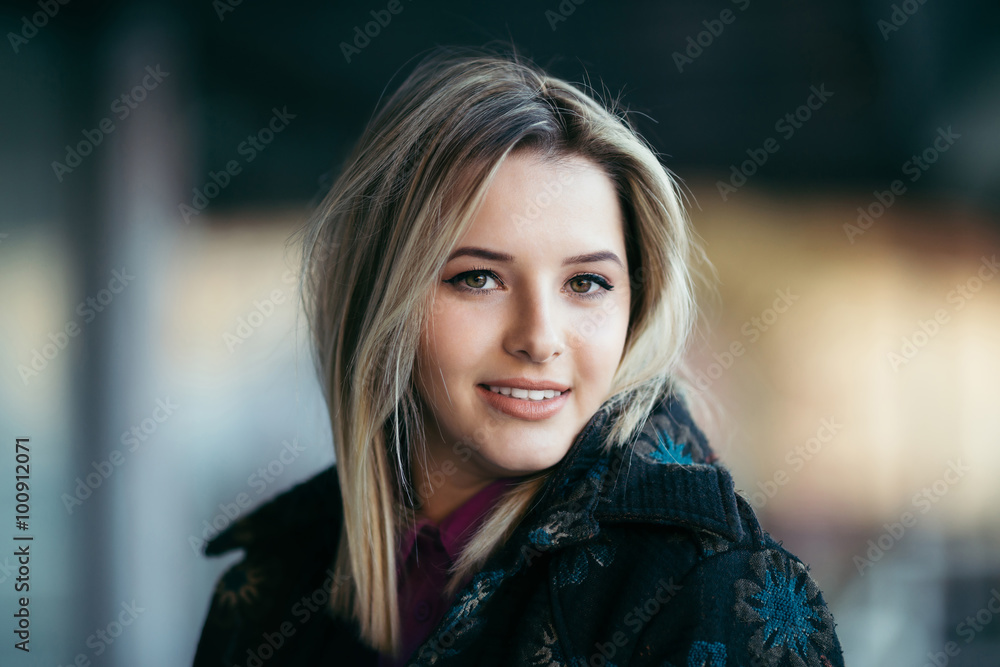 Fashionable young and beautiful woman smiling and posing outside in a city street Fashionable young and beautiful woman smiling and posing outside in a city street