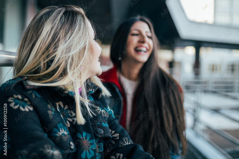 Two beautiful happy girls smiling and having a good time on the urban background. Young active people. Outdoors leisure activity. Two beautiful happy girls smiling and having a good time on the urban background. Young active people. Outdoors leisure activity.