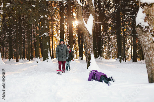 Young family having fun in winter forest