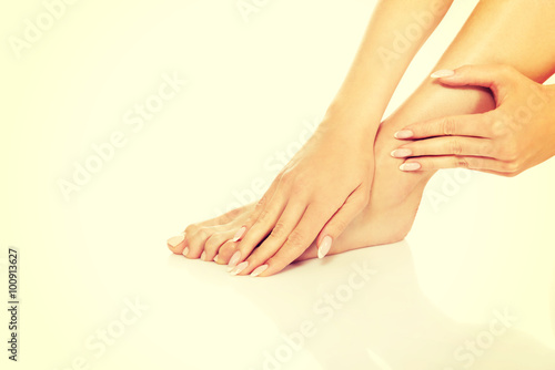 Fototapeta Naklejka Na Ścianę i Meble -  Young naked woman touching her foot