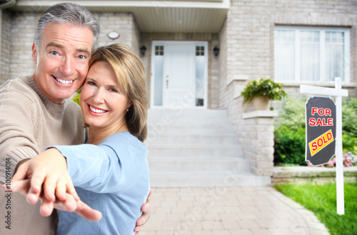 Happy senior couple near new house. © grinny