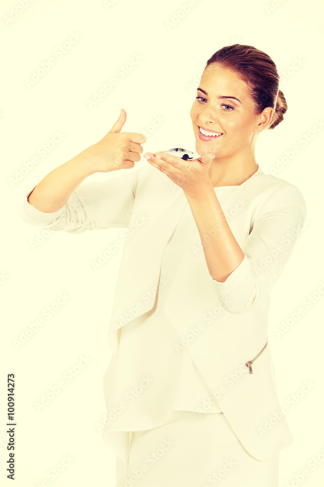 Young businesswoman holding a toy car Young businesswoman holding a toy car
