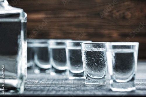  selectiv focus glasses of vodka on wooden table