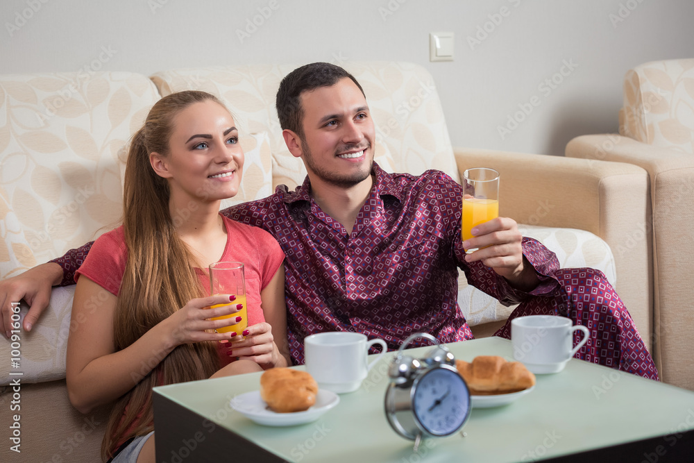 Cute young couple having breakfast, eating croissants, drinking orange juice. Cute young couple having breakfast, eating croissants, drinking orange juice.