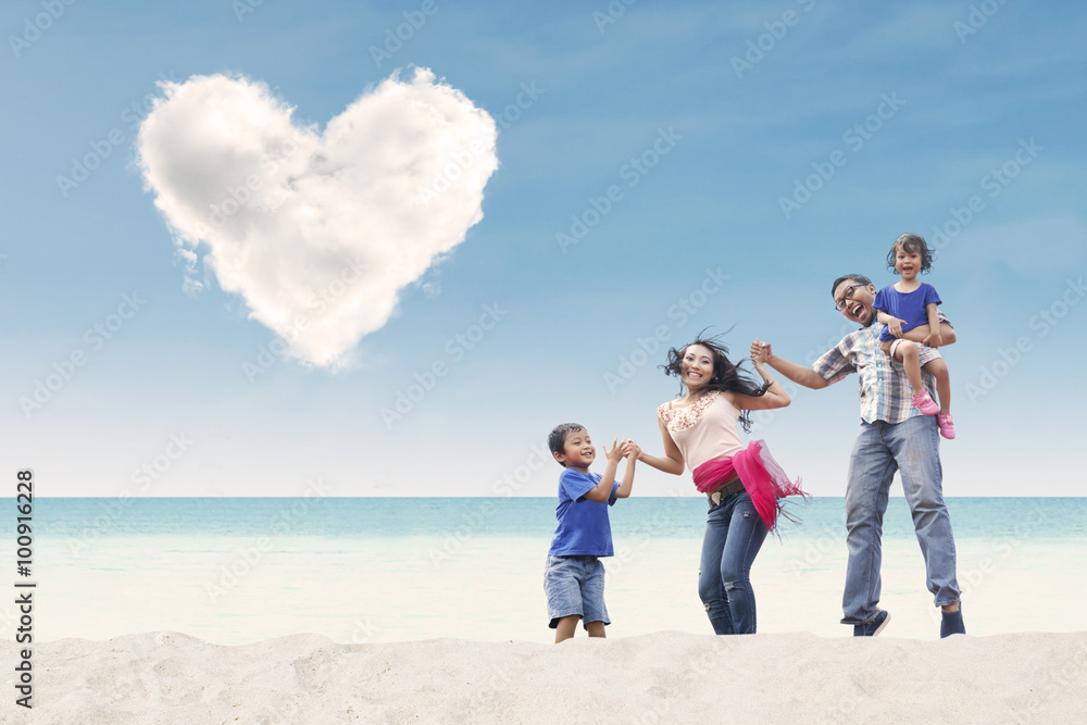 Happy family at beach under heart cloud Happy family at beach under heart cloud