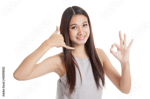 Young Asian woman show with phone gesture and OK sign