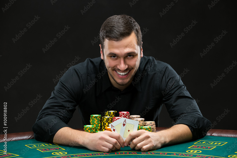 Happy poker player winning and holding a pair of aces Happy poker player winning and holding a pair of aces