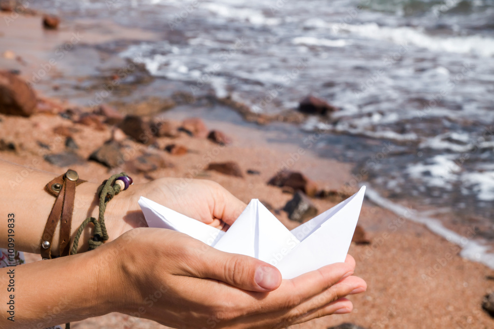 Paper ship in hands