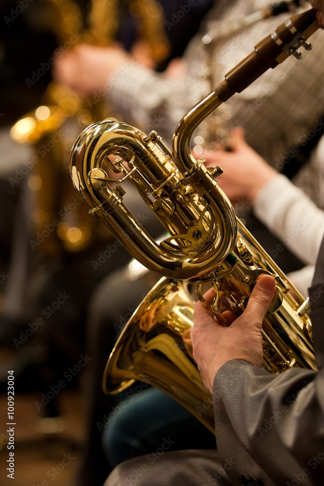 Obraz premium Detail baritone saxophone in the hands of a musician in the orchestra 