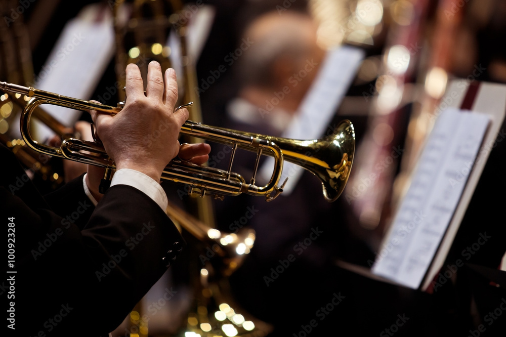 Obraz premium Hands of man playing the trumpet in the orchestra in dark colors
