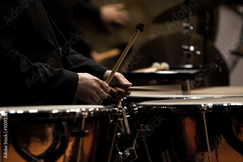 Hands musician playing timpani in dark colors closeup