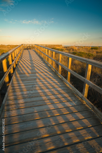 Footbridge to the sea at sunset near the San Pedro del Pinatar. Region of Murcia. Spain