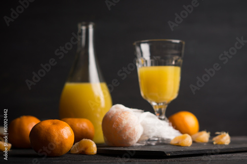 Oranges and juice on the dark background. Shallow depth of field. 