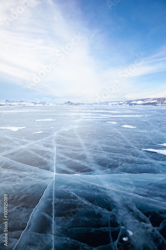 Winter ice landscape on lake Baikal with dramatic weather clouds