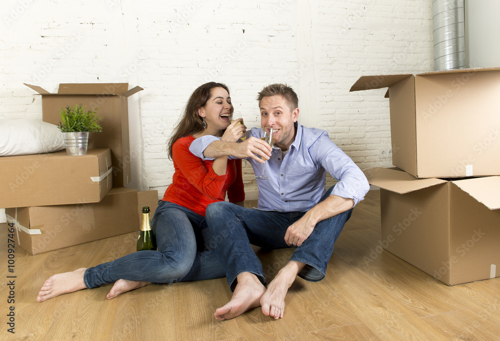 happy American couple sitting on floor unpacking together celebrating with champagne toast moving in a new house happy American couple sitting on floor unpacking together celebrating with champagne toast moving in a new house
