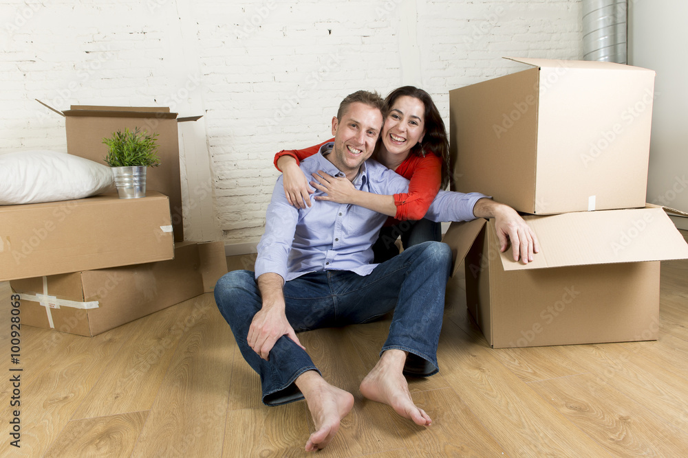 young happy couple sitting on floor together celebrating moving in new flat house or apartment young happy couple sitting on floor together celebrating moving in new flat house or apartment
