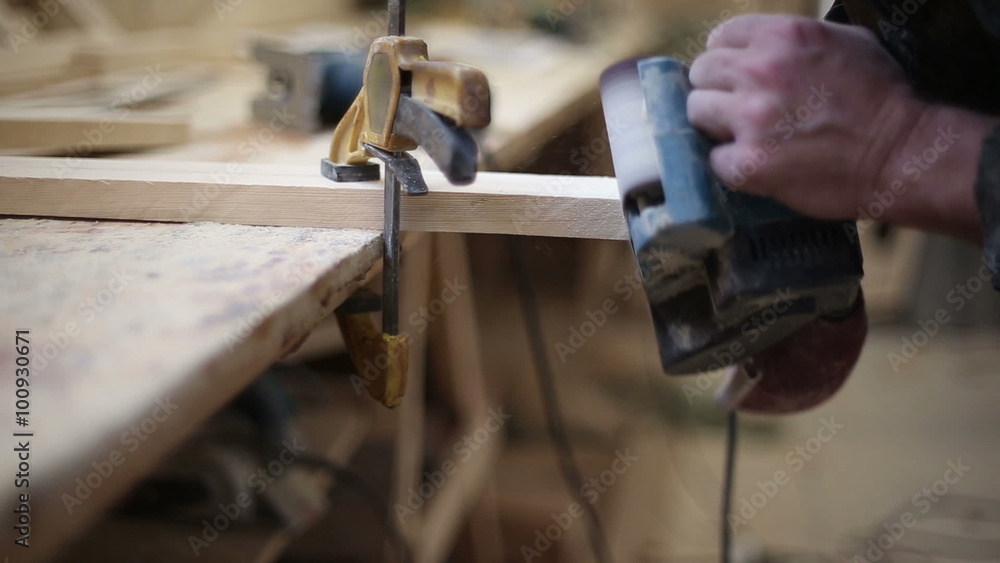 A carpenter polishes a piece of wood clamped in a vise belt using sander machine
A carpenter polishes a piece of wood clamped in a vise belt using sander machine