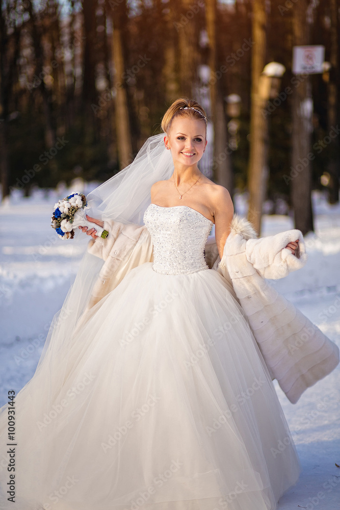 The bride in a wedding dress on a Sunny winter day, one